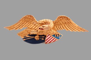 A gold eagle with an american flag on it's wings.